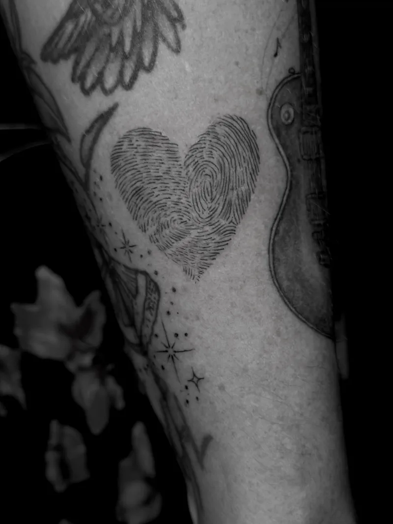 Black and grey fingerprint heart with wings and stars