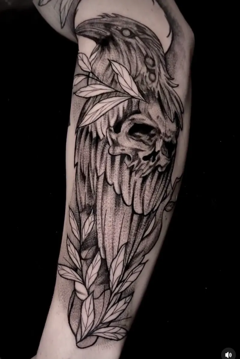 Blackwork raven and skull with leaves along the forearm