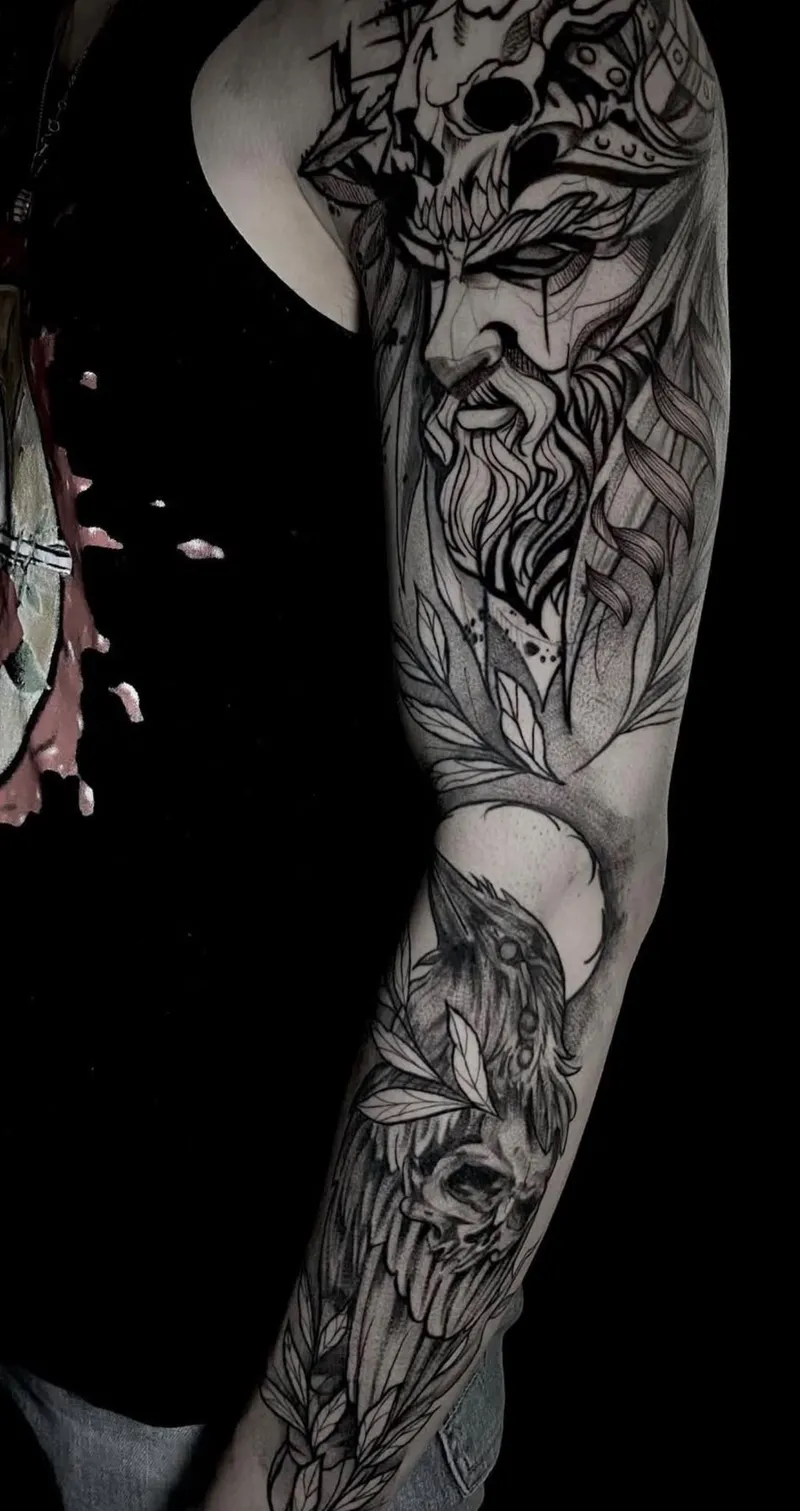 Full blackwork sleeve tattoo: a bearded warrior under a horned skull on the shoulder, with a raven and leaves down the forearm, by Nataly Fierro in Omaha
