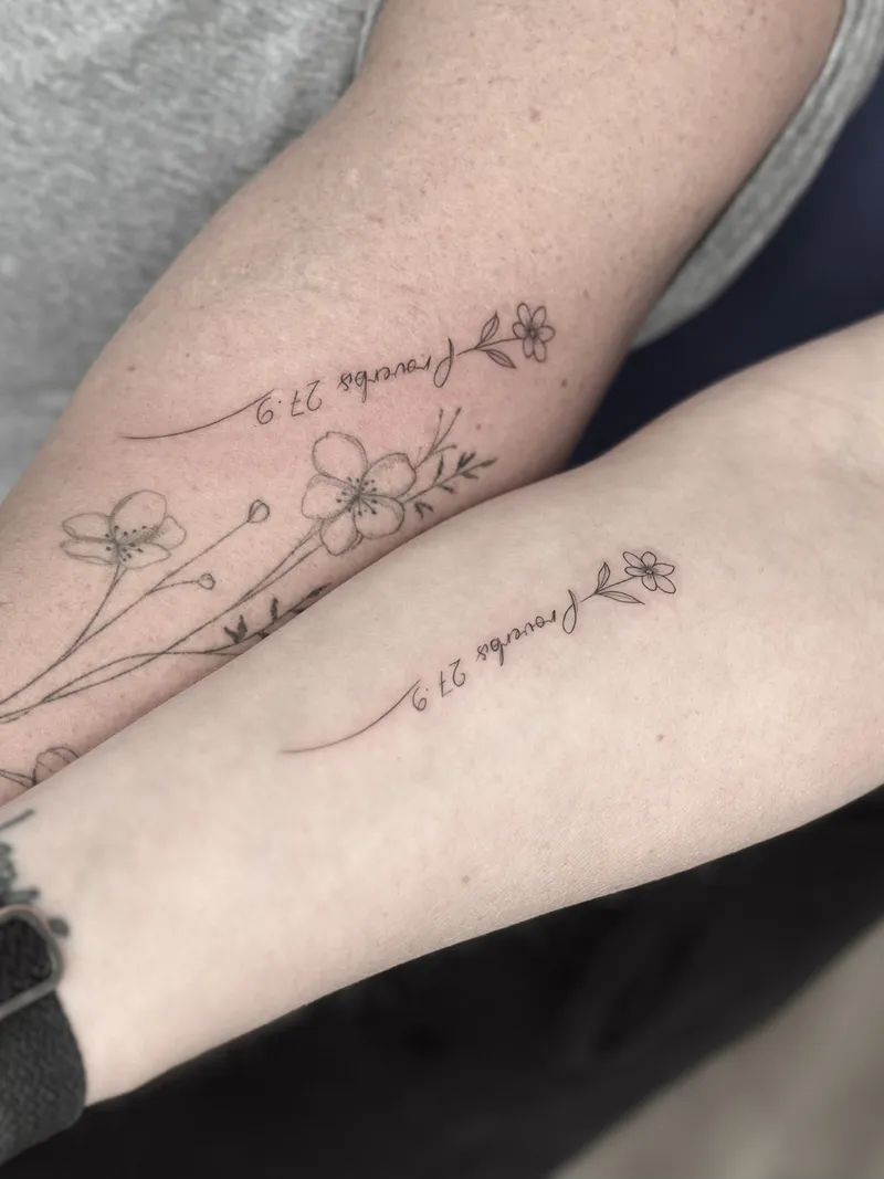 Matching fine line script and blossoms on both forearms