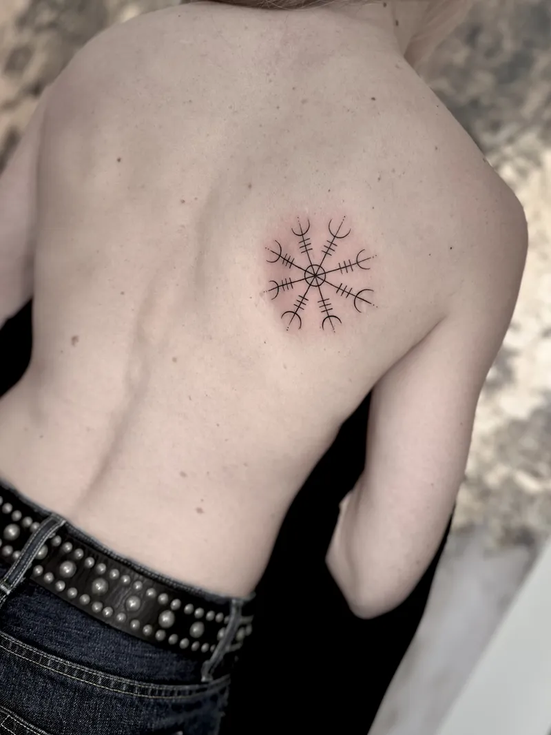Small fine line botanical burst on the upper back
