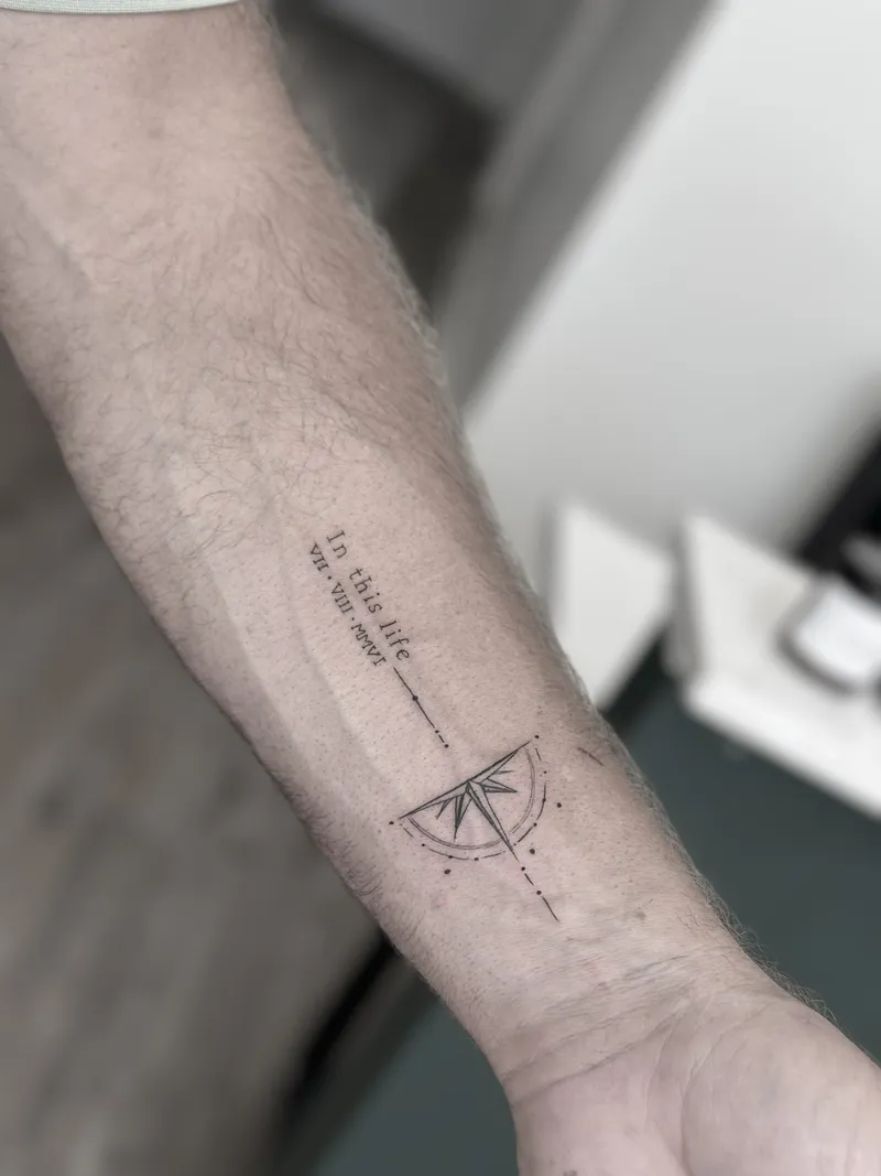 Fine line compass with a dotted line and script on the forearm