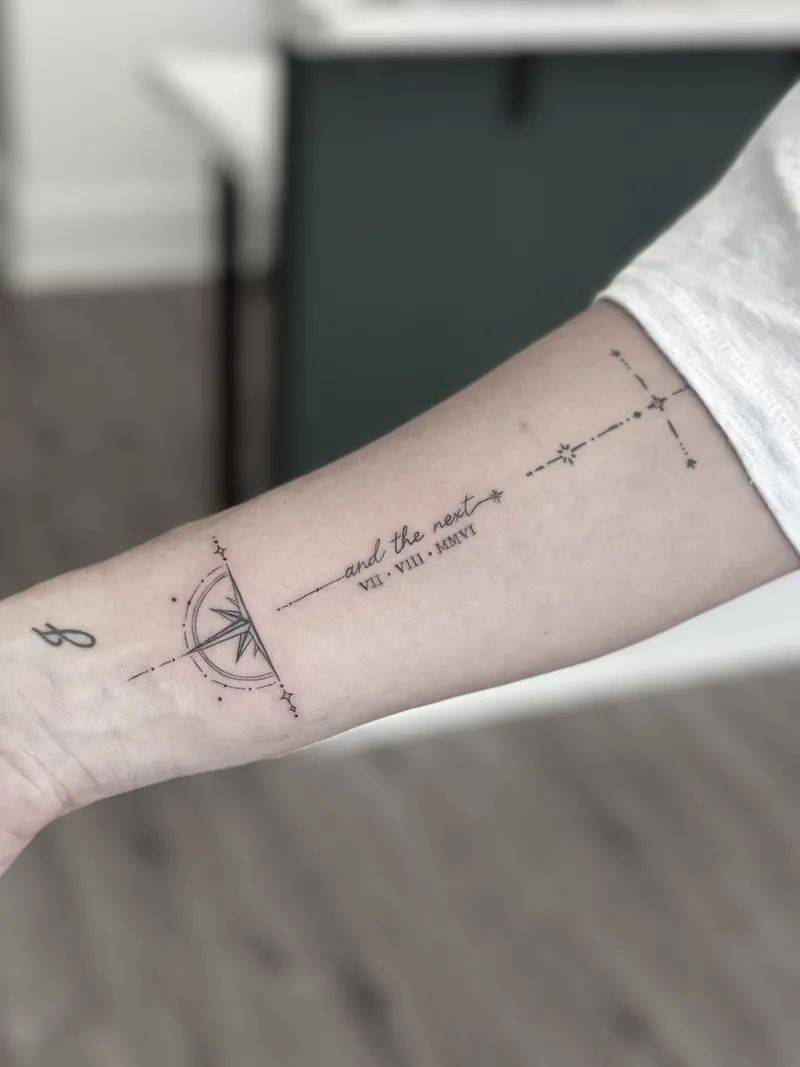 Fine line compass, arrow and script running along the forearm