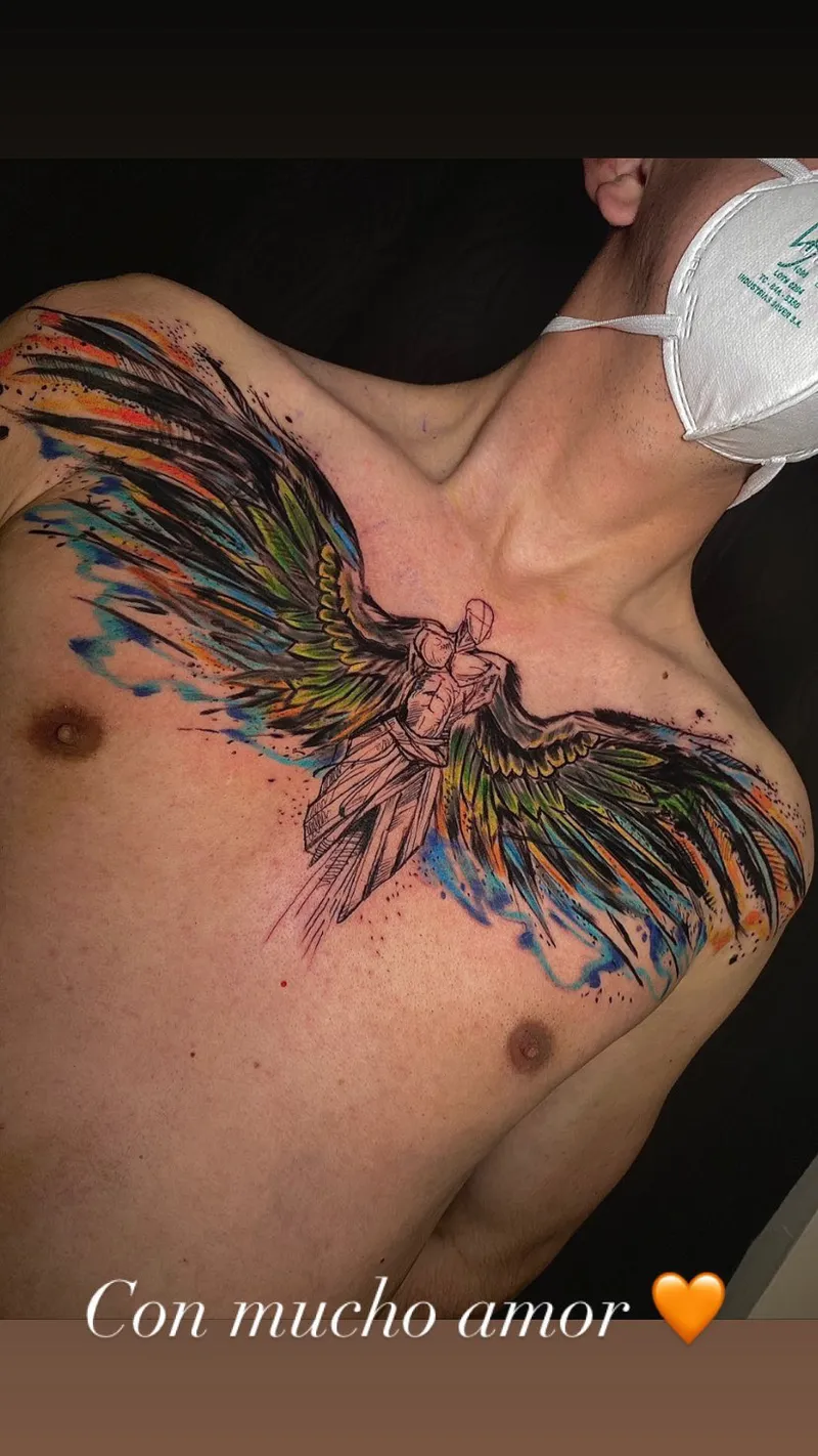 Watercolor phoenix tattoo with wings across the collarbones in blue, green and red