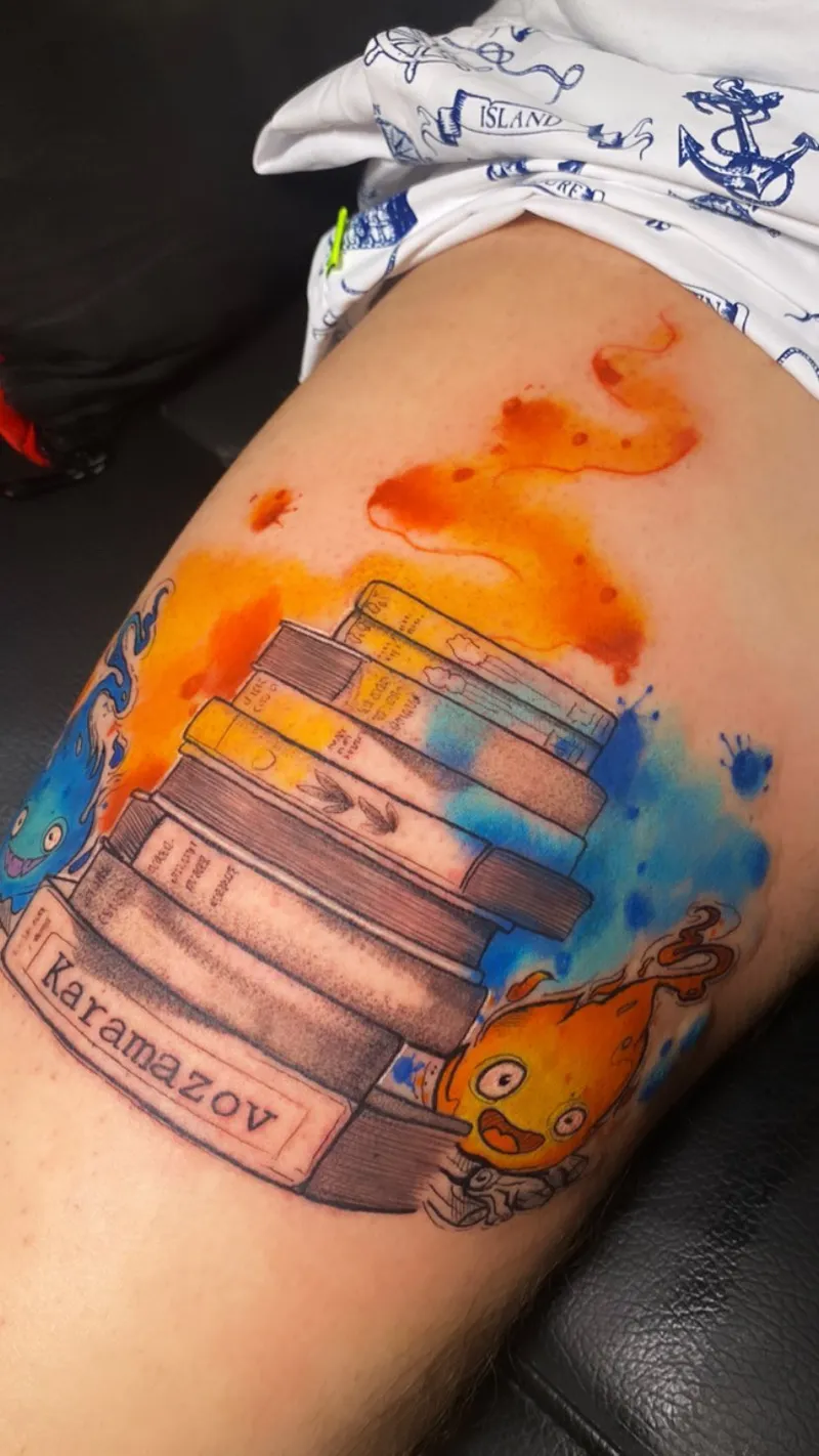 Stack of books with orange and blue watercolour splashes on the thigh